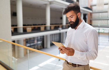 Handsome young businessman using his digital tablet