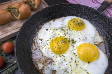 appetizing fried eggs in an old frying pan