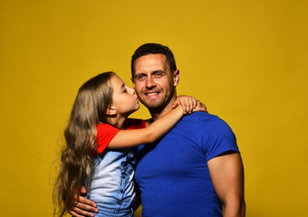 Man and girl hug on yellow background.