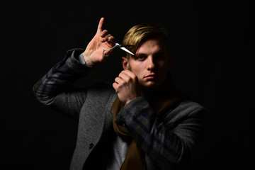 Man with scissors. Macho in coat holds metal scissors