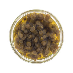 Top view of marinated gourmet green beans in an open jar isolated on a white background.