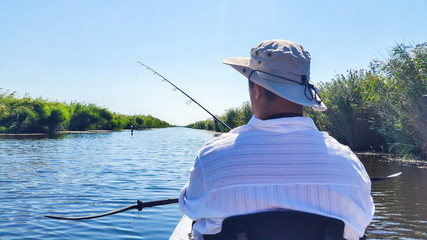 Man in kayak fishing with artificial lure