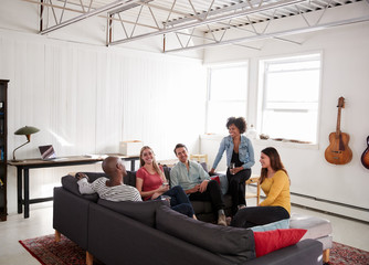 Fototapeta premium Five young friends socialising in a New York loft apartment