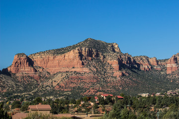 Large Red Rock Mountain Overlooking Valley With Homes