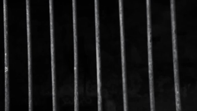 Jail or prison cell. Obsolete gray grunge concrete room. Iron baluster or steel Cage. Old prison bars cell lock background dark black and light