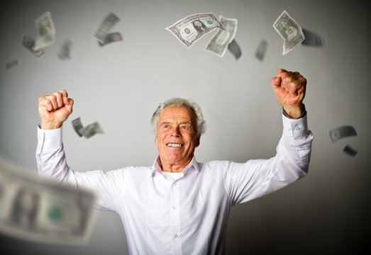 Happy old man in white and falling dollar banknotes