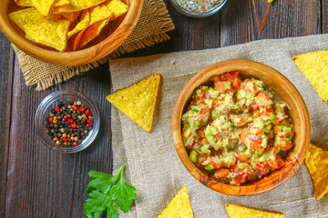 Guacomole is a traditional Mexican sauce consisting of grated avocado, lime juice, red onion, tomatoes, garlic and chili. Served with nachos chips.