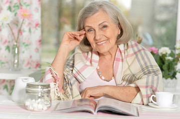  happy aged woman  reading magazine