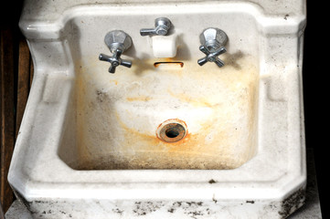 Unclean old dirty restroom wash basin displayed indoors.