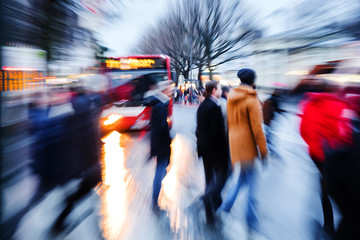 people crossing a city street at dusk