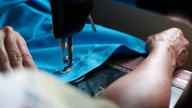 Seamer working with blue fabric from high angle view