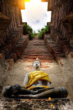 Ancient Buddha and old brick wall on ancient monuments that are over 200 years old. Wat Nakhon Luang Tample,Prasat Nakhon Luang public domain or treasure of Buddhism in  Ayutthaya, Thailand