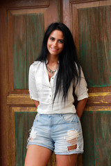 Attractive young woman next to a wooden door