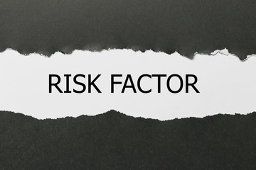 The text RISK FACTOR appearing behind torn paper