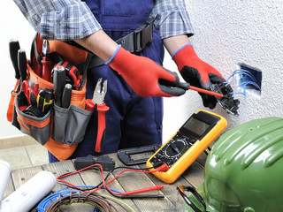 Young electrician technician works in compliance with safety standards in a residential electrical...