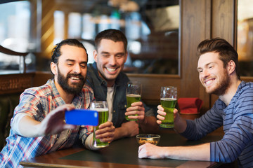 friends taking selfie with green beer at pub
