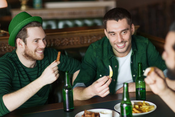 male friends drinking green beer and eating at pub