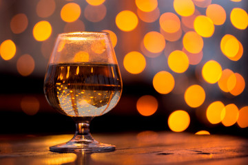 Glass of wine on a table in the background of a yellow bokeh