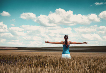 Woman standing in a corn field rejoicing