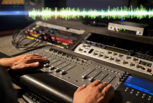 hands on mixing console at sound recording studio