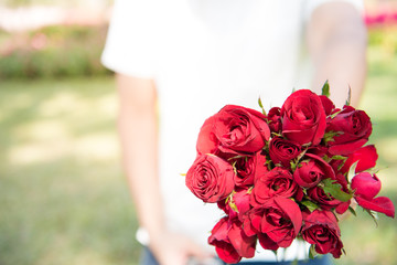 man is standing and holding roses. background of valentine day concept and love concept. copy space for text.