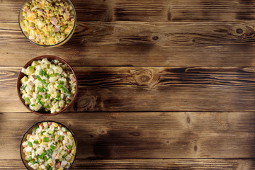 Set of festive mayonnaise salads on wooden table. Top view