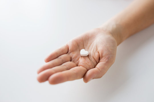 Close Up Of Hand Holding Medicine Heart Pill