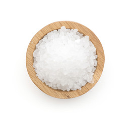 Sea salt in a wooden bowl top view isolated on white background.