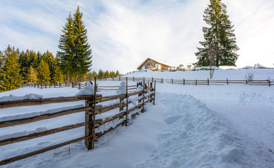 winter chalet in mountain. Trails and path of hikers on the snow