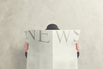 man with bowler reading news