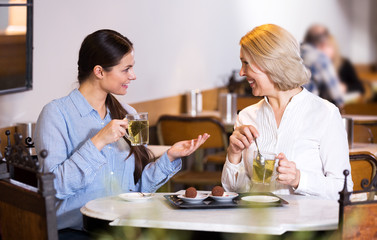 Young and mature woman drinking tea and talking