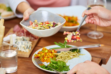 people eating salad at table with food