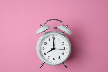 vintage alarm clock on solid pastel pink color background