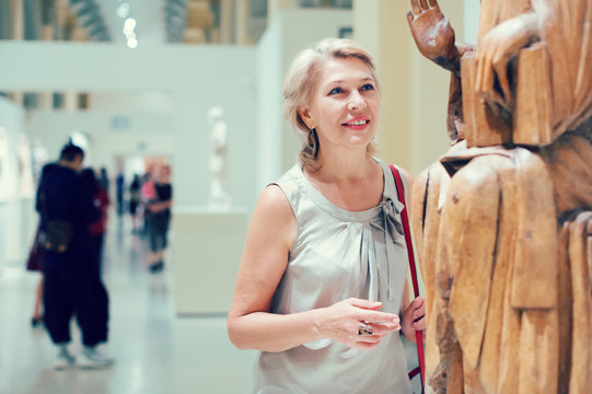 Portrait of woman visitor near sculpture