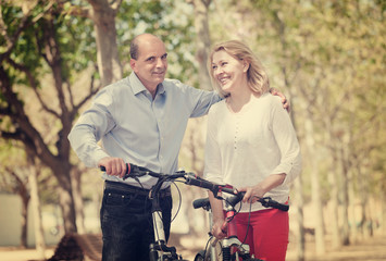 Fototapeta na wymiar Happy couple walking with bicycles