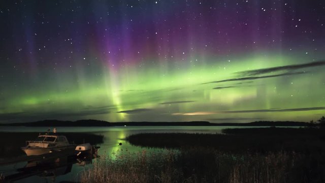 Tilt up, scenic aurora borealis timelapse over docks in Finnish Archipelago