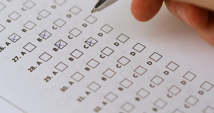 student hand with pen fill in exam test answer sheet