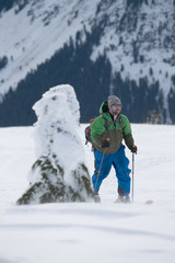 Young man ski touring in the mountains