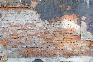 old brick wall with cracked plaster