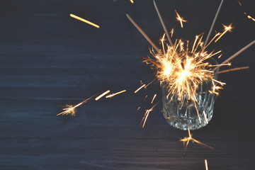 Sparkler in the glass. Holidays lights. New Year celebration. 