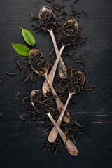 Dry black tea. On a wooden background. Top view. Copy space.