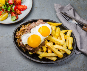 Peruvian Latin American food. Lomo a lo pobre. Beef tenderloin whit fried potatoes french fries and eggs
