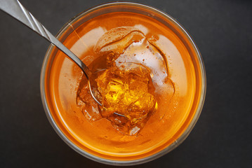 A glass of Orange Jellye with spoon on black background. Citrus jelly. Top View.