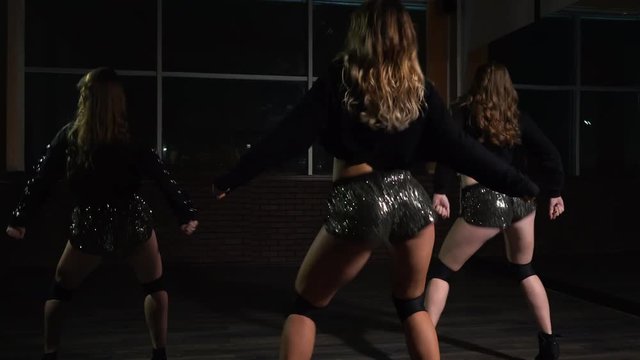 young sexy girls in shorts are dancing twerk in the dance studio, steadicam shot