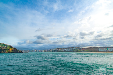 A view of San Sebastian, Spain with scenic sky from the sea with turquoise water 