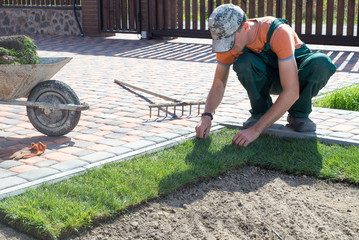 Landscape Gardener Laying Turf For New Lawn