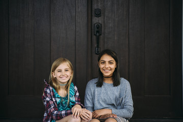 Portrait of friends sitting at doorway