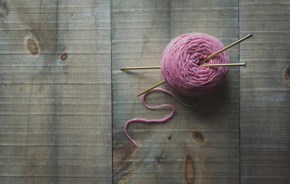 High angle view of woolen ball with knitting needles on table