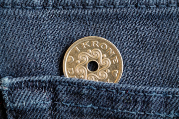 Denmark coin denomination is one krone (crown) in the pocket of blue denim jeans