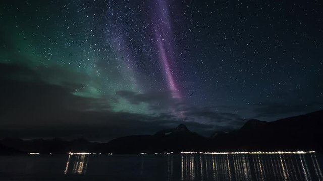 Tilt down, aurora borealis timelapse above Norway fjord
